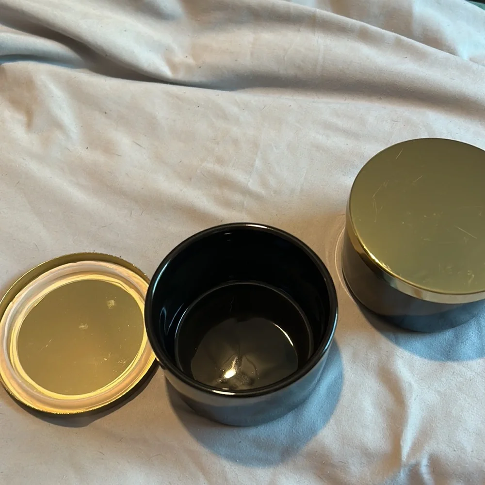 Two black jars with gold lids